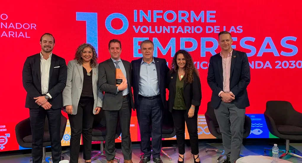 Grupo de personas con un premio con un fondo rojo